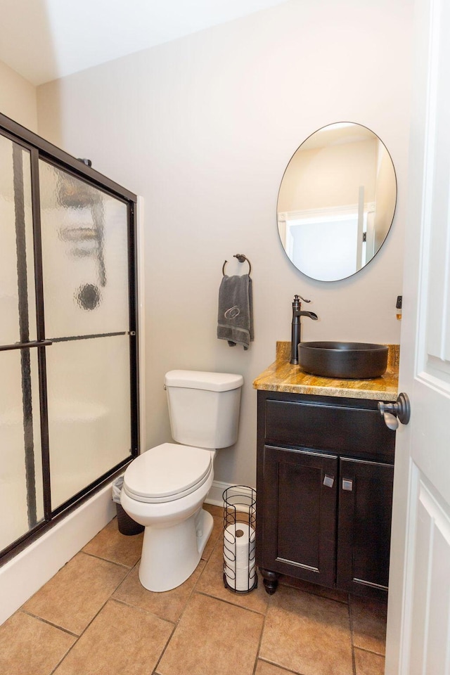full bath featuring a shower stall, tile patterned flooring, vanity, and toilet