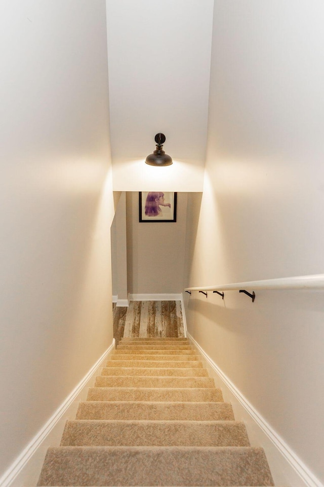 staircase with wood finished floors and baseboards
