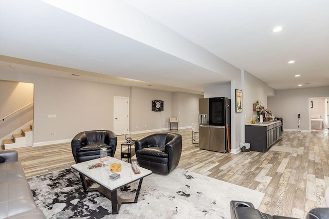 living room with light wood-style floors, recessed lighting, baseboards, and stairs