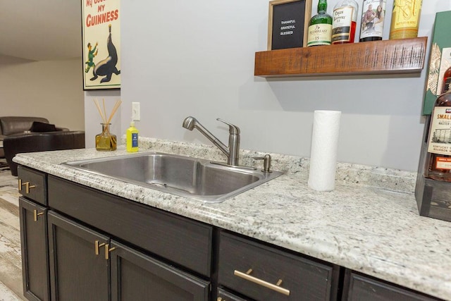 kitchen with a sink, open shelves, and dark brown cabinetry