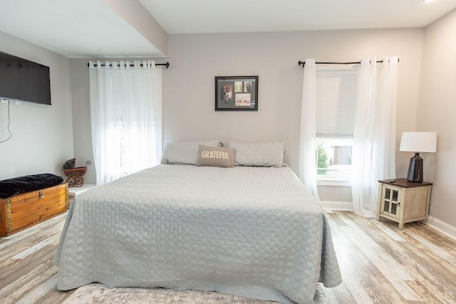 bedroom with baseboards and wood finished floors