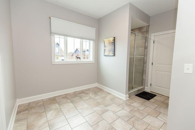 full bathroom featuring a stall shower and baseboards