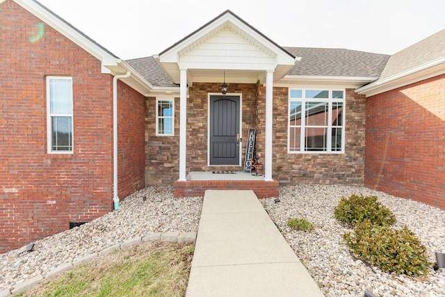 doorway to property with roof with shingles and stone siding