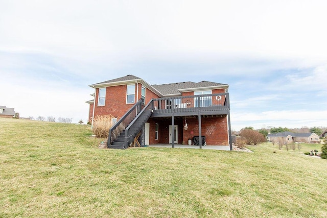rear view of house featuring a deck, a yard, a patio area, stairs, and brick siding