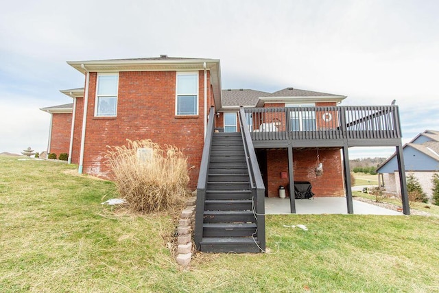 rear view of house with stairway, a patio area, brick siding, a deck, and a lawn