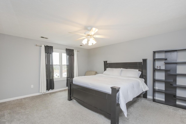 bedroom with baseboards, visible vents, light colored carpet, and ceiling fan