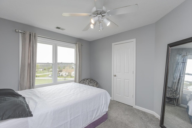 bedroom with baseboards, visible vents, carpet, and multiple windows