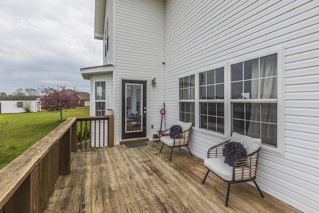 wooden terrace featuring a lawn