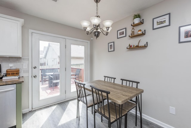 dining room with light wood finished floors, baseboards, and a chandelier