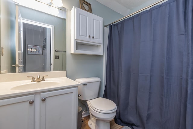 full bathroom featuring wood finished floors, vanity, curtained shower, and toilet