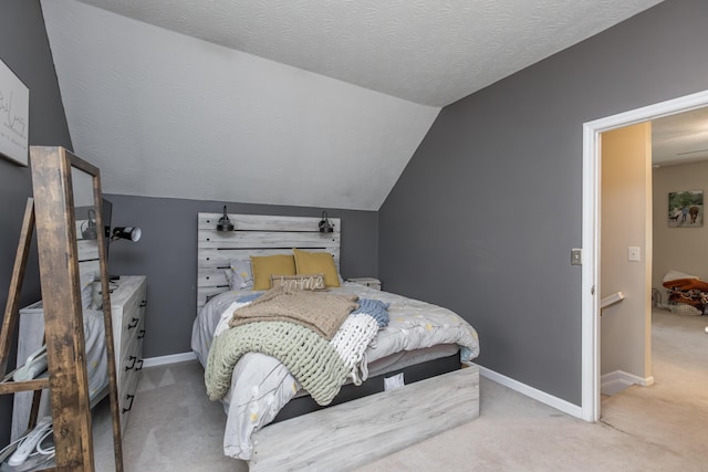carpeted bedroom with vaulted ceiling and baseboards