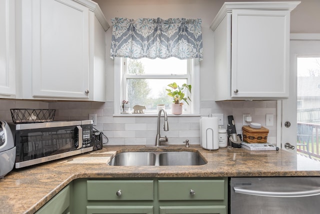 kitchen featuring white cabinets, green cabinetry, stainless steel appliances, and a sink