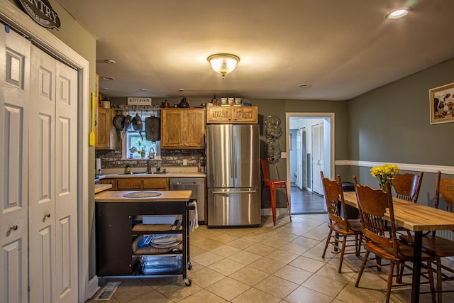20 Hemlock Subdivision Rd, Williamsburg, KY 40769 - kitchen featuring stainless steel appliances, tasteful backsplash, light countertops, brown cabinetry, and light tile patterned floors