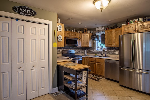 20 Hemlock Subdivision Rd, Williamsburg, KY 40769 - kitchen featuring stainless steel appliances, a sink, light countertops, light tile patterned floors, and decorative backsplash
