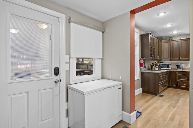 laundry room featuring light wood-style floors, recessed lighting, visible vents, and baseboards