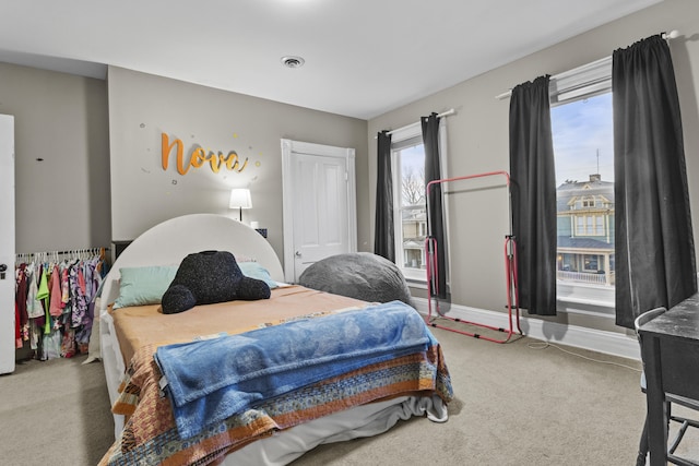 bedroom with baseboards, multiple windows, and carpet