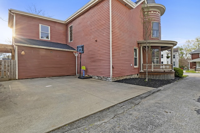view of side of home with fence and a porch