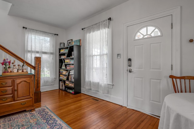 entrance foyer featuring wood finished floors, visible vents, and a healthy amount of sunlight