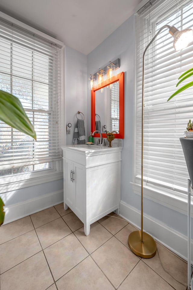 bathroom with vanity, tile patterned flooring, and baseboards