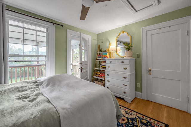 bedroom with attic access, light wood-style flooring, access to exterior, baseboards, and ceiling fan