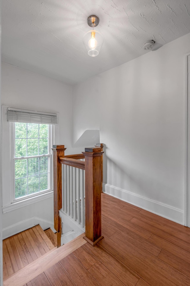 stairs featuring wood finished floors and baseboards