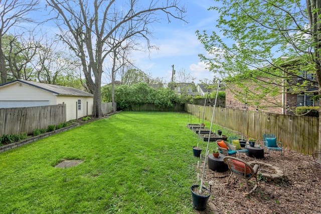 view of yard with a detached garage and a fenced backyard