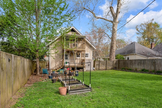 exterior space with a fenced backyard, a vegetable garden, a balcony, and a gate