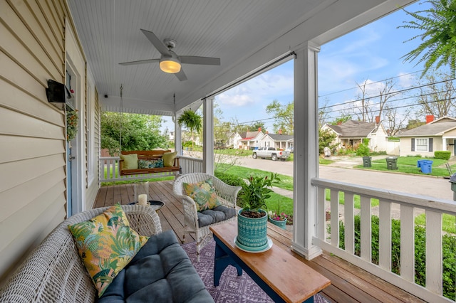 wooden deck with a residential view, a ceiling fan, and covered porch