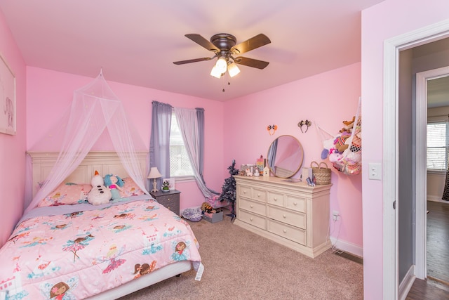 bedroom with a ceiling fan, baseboards, and carpet