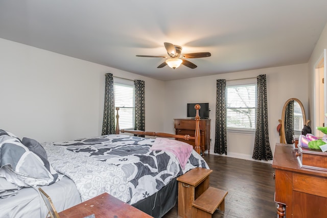 bedroom with baseboards, dark wood-type flooring, ceiling fan, and multiple windows