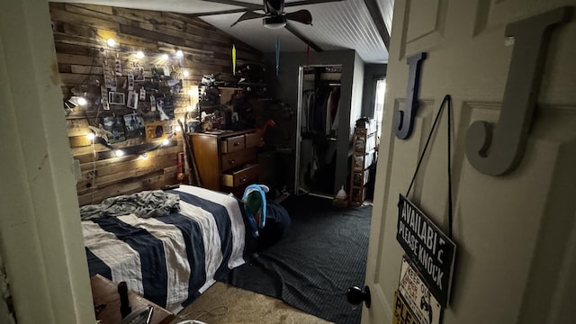 carpeted bedroom with wooden walls and lofted ceiling