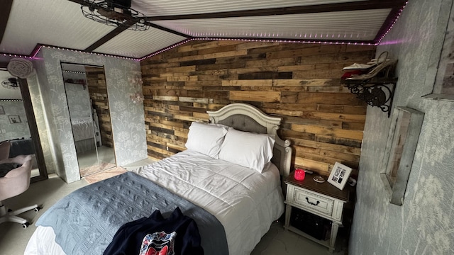 bedroom with concrete floors, vaulted ceiling, and wooden walls