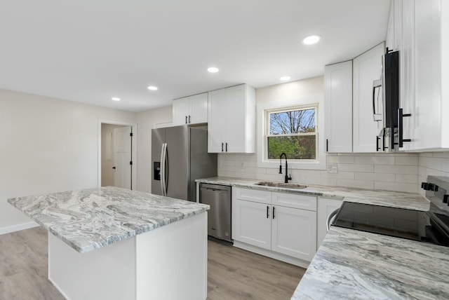 730 E Spencer Rd, Campton, KY 41301 - kitchen featuring light wood finished floors, a center island, a sink, light stone countertops, and appliances with stainless steel finishes