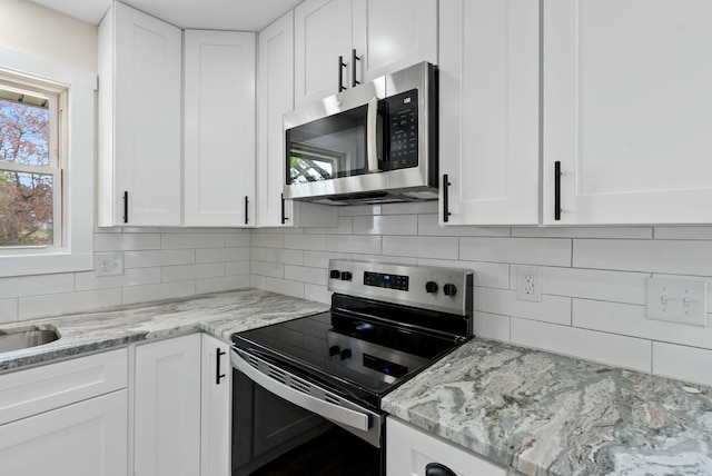 730 E Spencer Rd, Campton, KY 41301 - kitchen featuring white cabinets, stainless steel appliances, light stone countertops, and backsplash