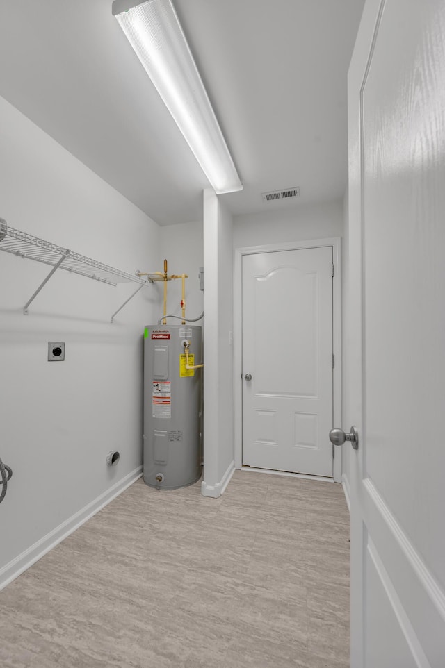 laundry area featuring visible vents, baseboards, laundry area, electric water heater, and electric dryer hookup