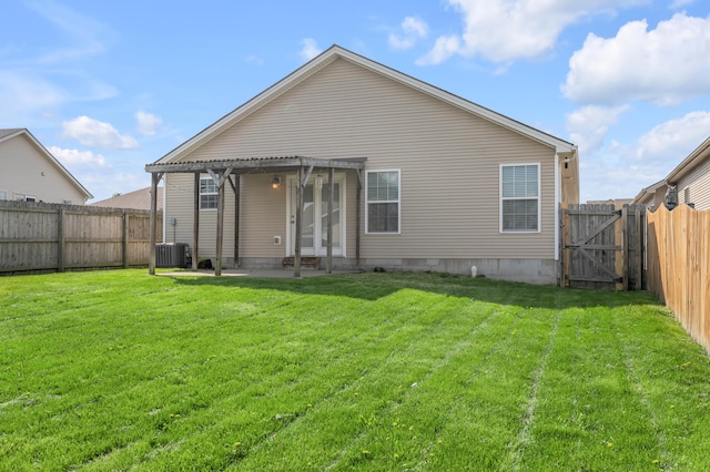 back of house featuring a fenced backyard, a gate, and a lawn