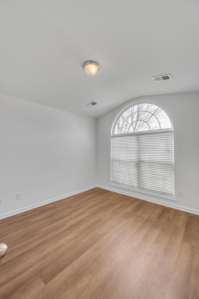 unfurnished room featuring light wood finished floors, baseboards, and visible vents