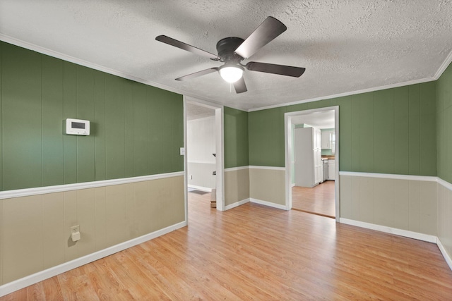 spare room featuring crown molding, a textured ceiling, ceiling fan, and wood finished floors