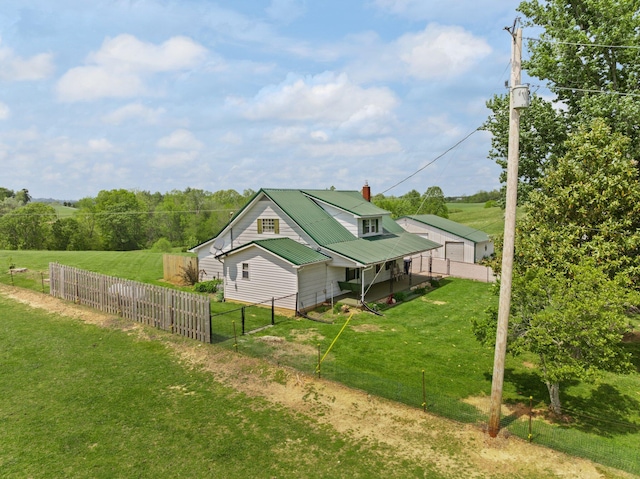 view of home's exterior with a lawn, fence, and metal roof