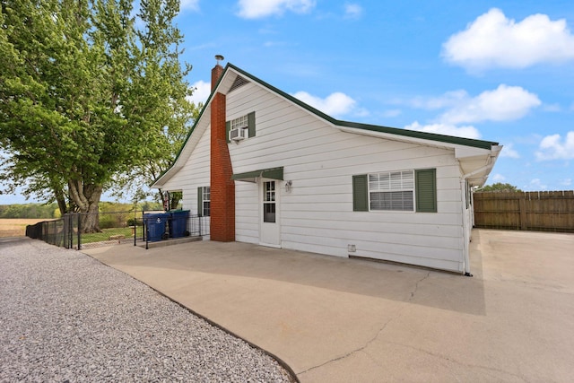 back of property featuring a patio, fence, and a chimney