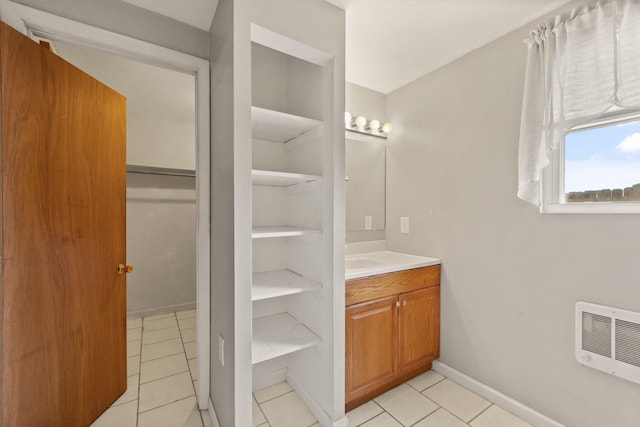 bathroom featuring tile patterned floors, heating unit, baseboards, and vanity