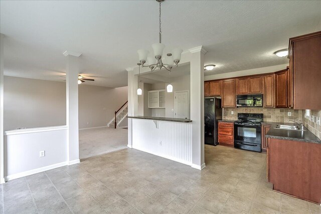 kitchen with a sink, dark countertops, open floor plan, baseboards, and black appliances
