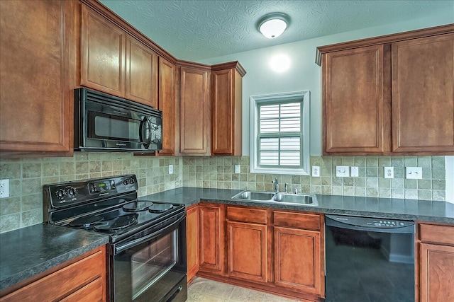 kitchen with dark countertops, a sink, and black appliances