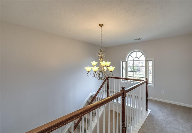 hallway with visible vents, an upstairs landing, carpet floors, baseboards, and a chandelier