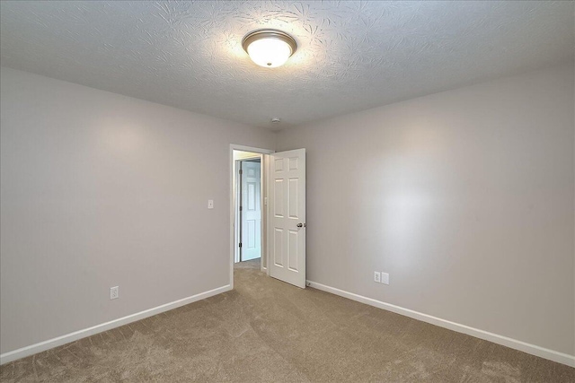 unfurnished room with baseboards, carpet flooring, and a textured ceiling