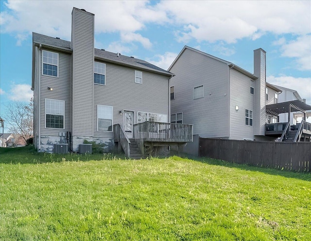 rear view of house featuring central AC, fence, a deck, and a yard