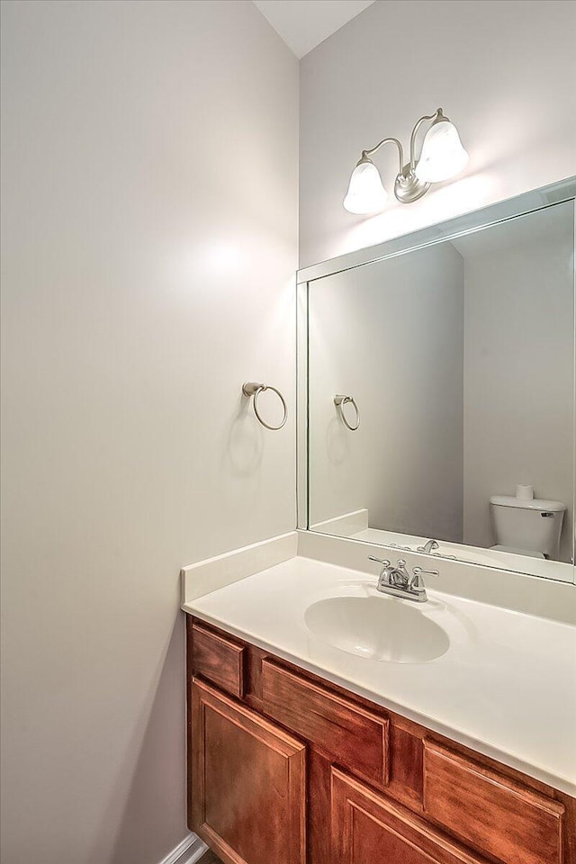 half bath featuring toilet and vanity