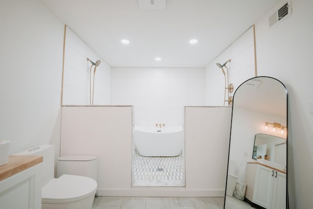 bathroom with visible vents, toilet, vanity, and tiled shower
