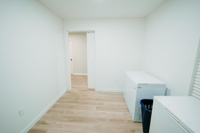 washroom featuring light wood-style flooring, baseboards, and separate washer and dryer