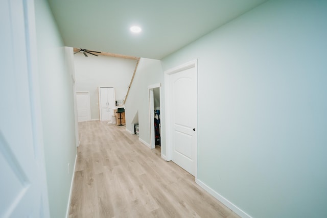 hallway featuring baseboards, recessed lighting, and light wood-type flooring